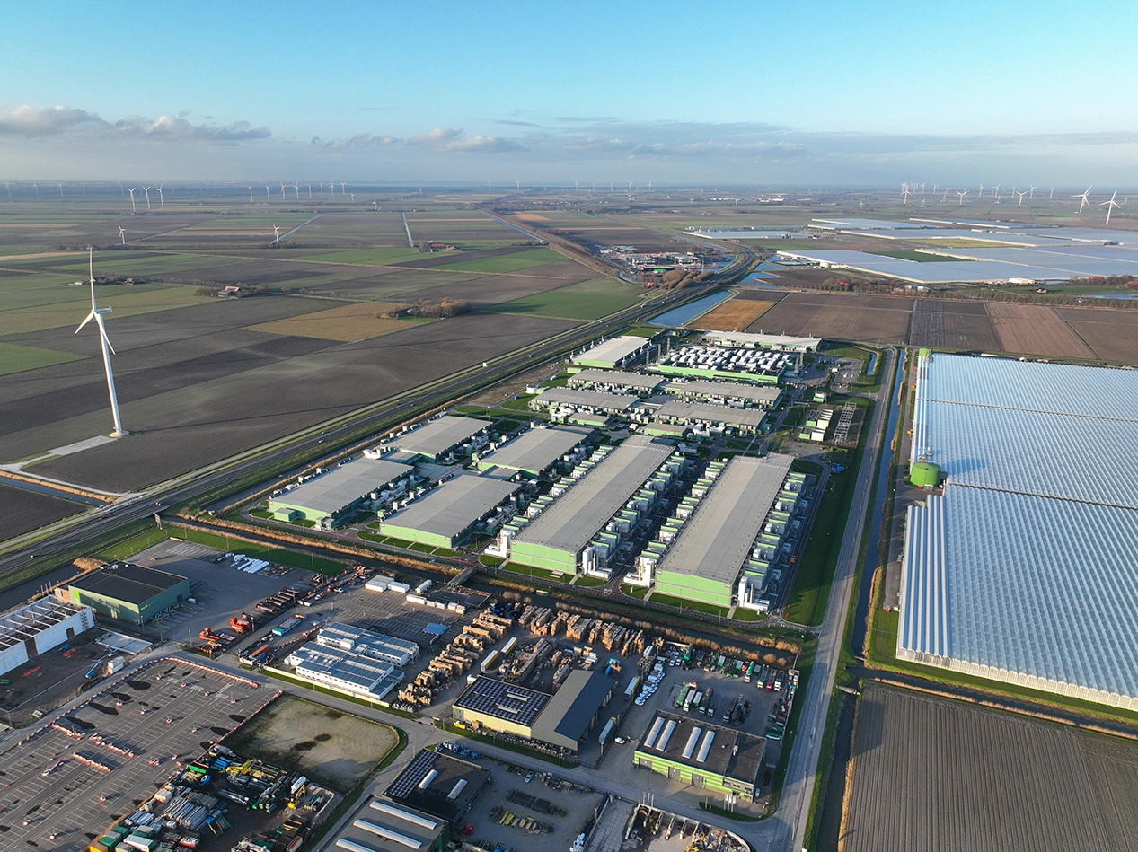 A large data centre with a wind turbine next to it